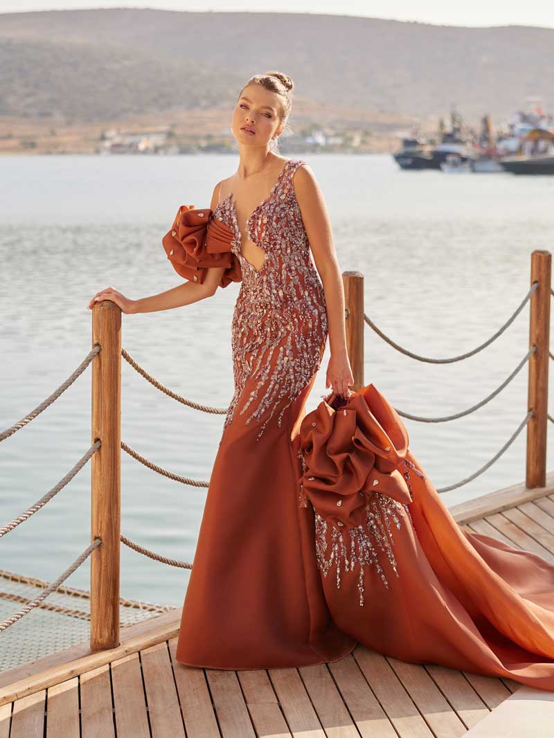 Close-up of the handcrafted crystal sequin drip embroidery and sculpted organza rose sleeve accent on the long prom gown.