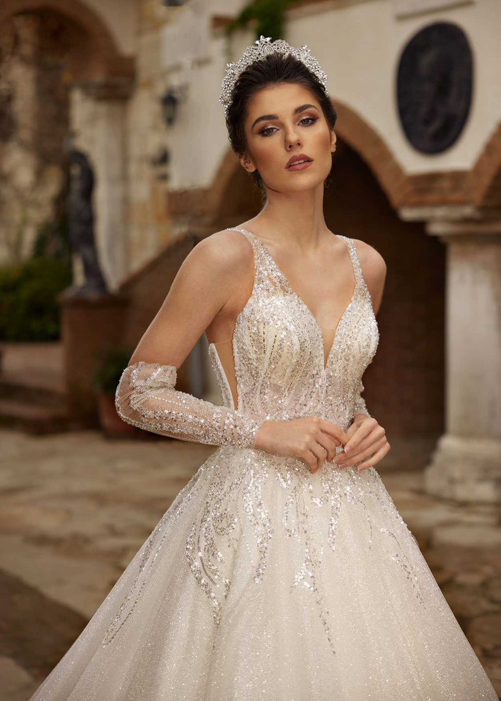 Front view of the V-neck sparkle ball gown wedding dress showing the statement detachable ruffled tulle sleeves by Sultan Dress.
